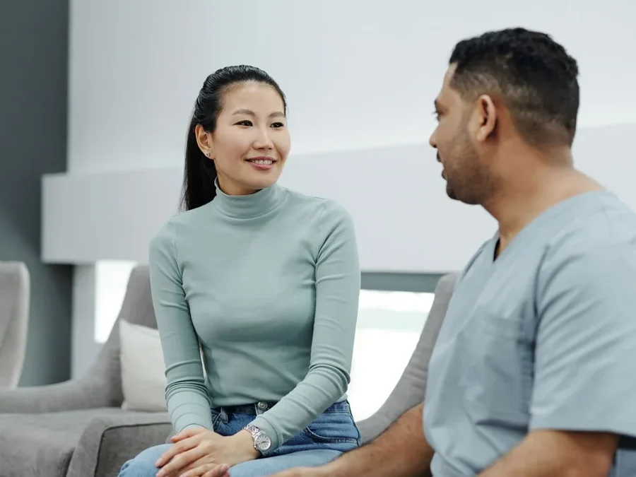 Doctor holding a tablet while explaining hair and scalp analysis results to a patient