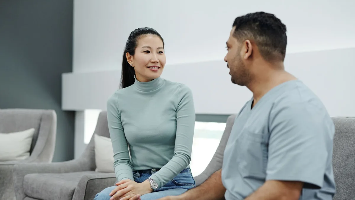 Doctor holding a tablet while explaining hair and scalp analysis results to a patient