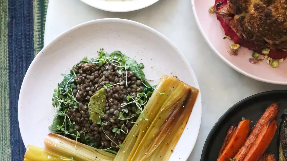 Table with healthy dishes of lentils, leafy greens and vegetables: iron-rich foods for hair health